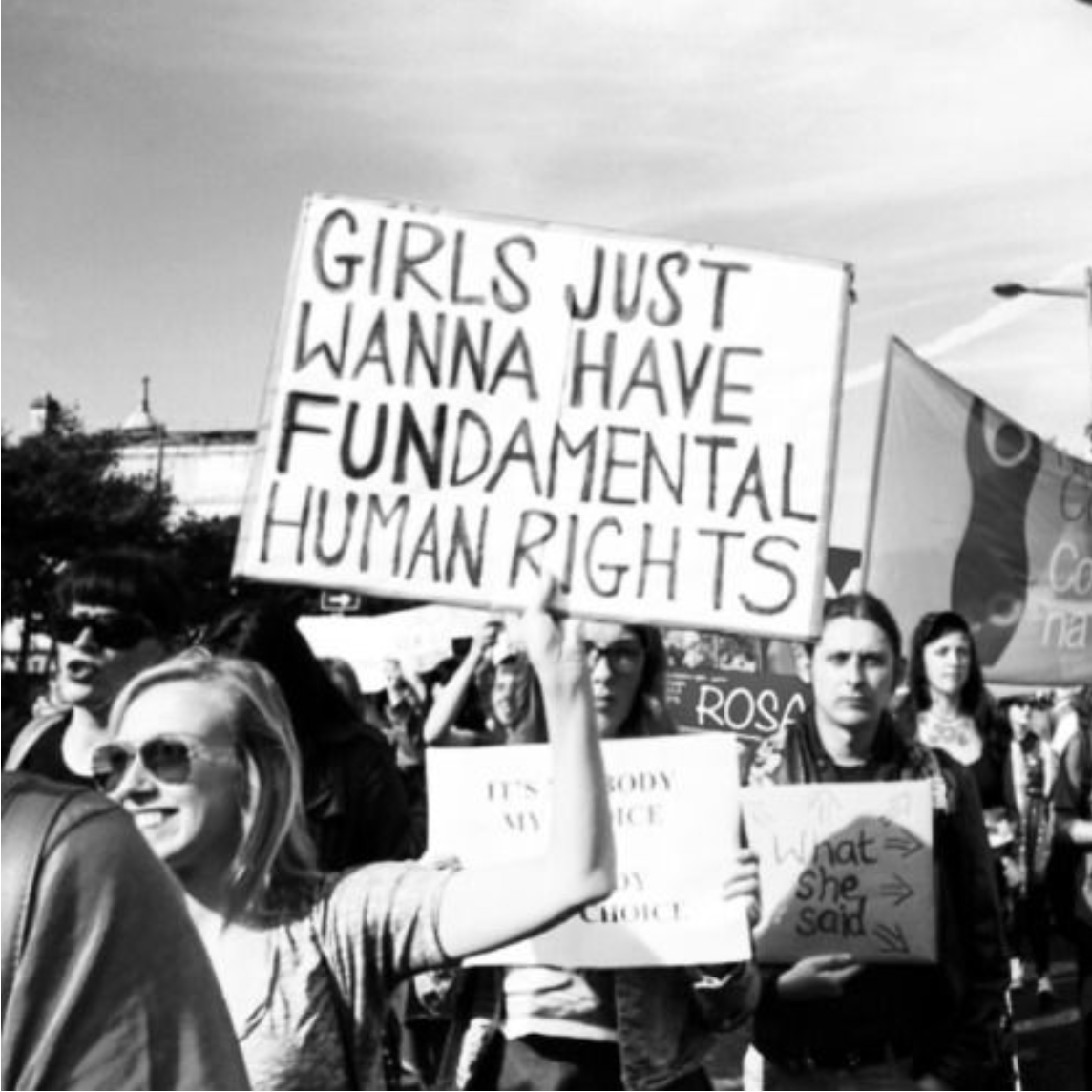 Protest with happy girl having a banner with the sign "girls just wanna have FUndamental rights"