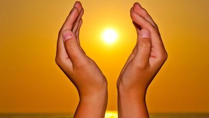 Children hands holding a sun in between