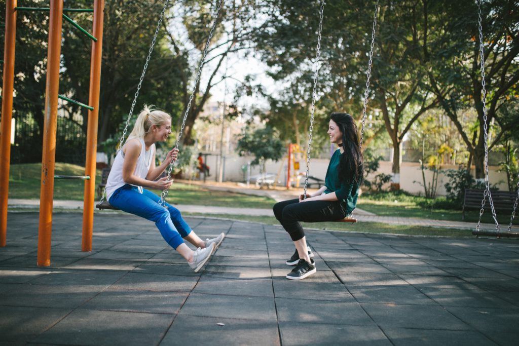 two young women talking on a playground